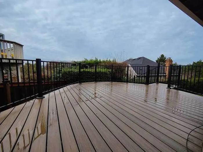 Deck in overcast weather with Trex composite decking boards and black aluminum picket railing.