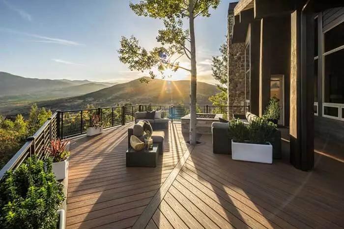 Large composite deck with horizontal rod railing during the sunset.